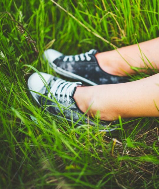 Hipnoza młodzieżowa - nogi nastolatka na trawie